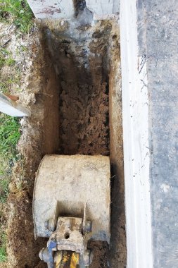 Ekskavatör bahçede küçük bir siper kazıyor..