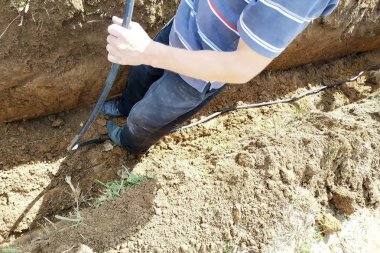 Usta bir elektrikçinin arazisine elektrik kablosu döşemek.