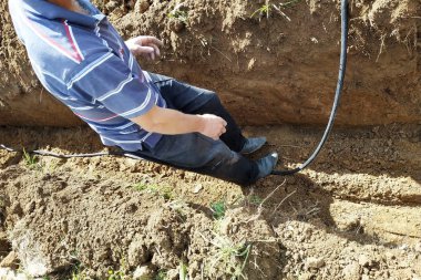 Usta bir elektrikçinin arazisine elektrik kablosu döşemek.