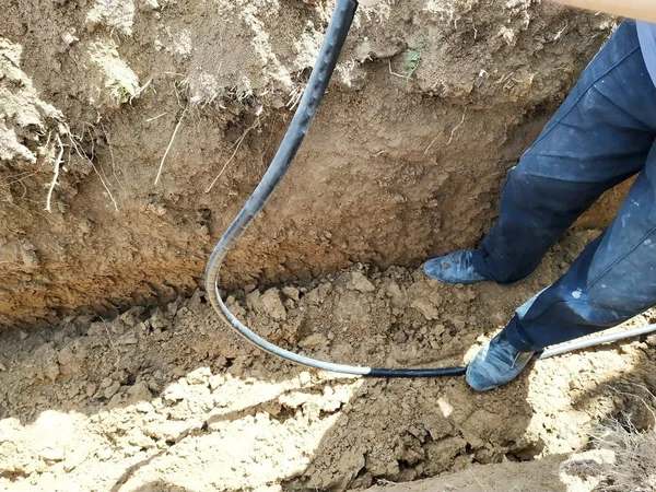Работник оградит электрический кабель в траншее. . — стоковое фото