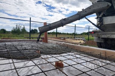 Bir şap yapmak için çelik takviye yerleştirdikten sonra beton dökme, fotoğraf kanalizasyon boruları gösterir.