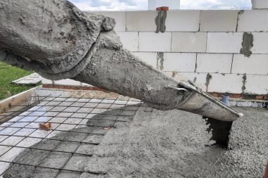 Beton karıştırıcı beton levha dökmek için oluk ile çimento besler, kanalizasyon boruları görülebilir.
