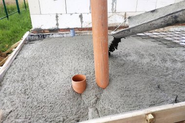 Beton karıştırıcı beton levha dökmek için oluk ile çimento besler, kanalizasyon boruları görülebilir.