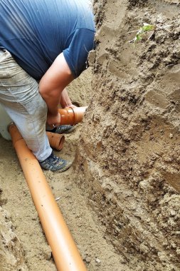 Müteahhit bir hendek te kanalizasyon kurar ve boruyu karterin.
