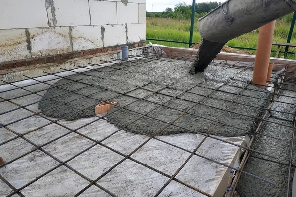 Hälla betong efter att ha placerat stålförstärkning för att göra en skriden, visar bilden avloppsledningar. — Stockfoto