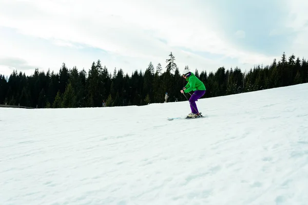 Um homem em uma roupa profissional corre da montanha esqui nas montanhas ucranianas — Fotografia de Stock