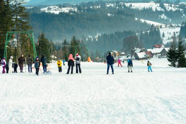 yablunivka, Ukrayna Şubat 5, 2019: Bir kask ve gözlük giyen yeşil ceketli bir adam Mount Koryvka üzerinde Karpat köyünde kayak gider.