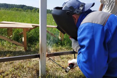 Şantiyede, ana çit için metal bir profil kaynak.