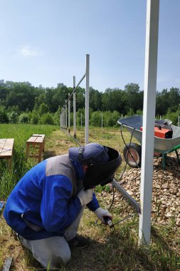 Şantiyede, ana çit için metal bir profil kaynak.