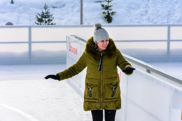 Bukovel, Ukraine February 12, 2019 - girl in green jacket skates on ice. — Stock Photo, Image