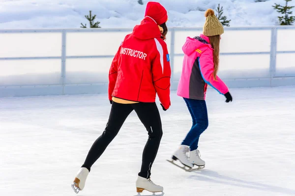 Bukovel, Ucrânia 12 de fevereiro de 2019 - menina de jaqueta vermelha instrutora de patinação no gelo em Bukovel . — Fotografia de Stock