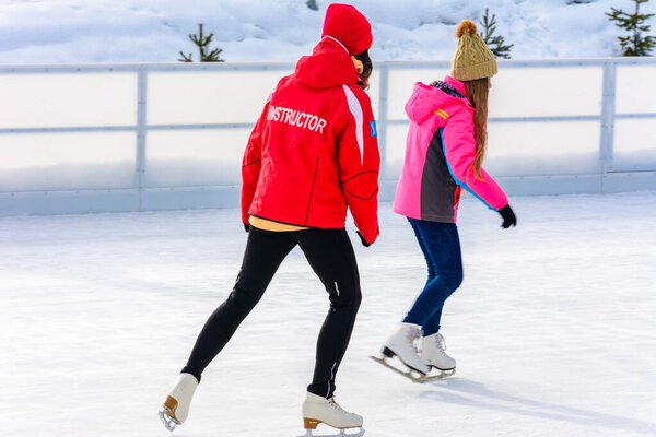 Bukovel, Ukraine February 12, 2019 - girl in a red jacket ice skating instructor in Bukovel.