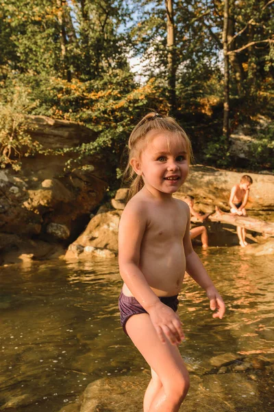 Pouco bonito linda menina nada em um rio de montanha . — Fotografia de Stock