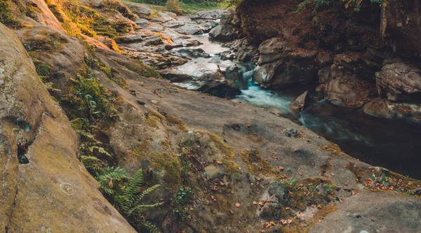 Sterke waterstroom in het hoge berggebied omringd door stenen met kleine moseilanden in het waterlichaam. — Stockfoto