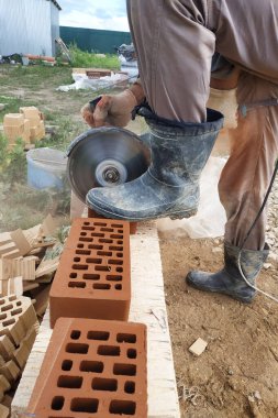 İşçi kırsal bir ön cephe tuğla ile bir köşe tuğla keser.