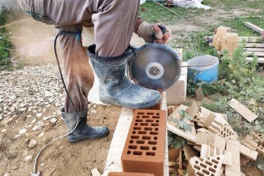 İşçi kırsal bir ön cephe tuğla ile bir köşe tuğla keser.