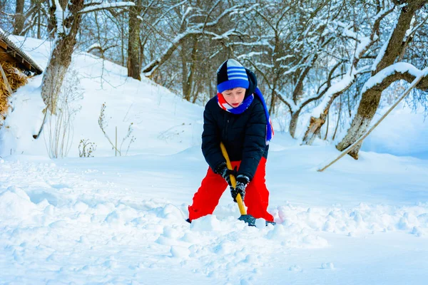 Ein kleiner Junge im Dorf reinigt den Schnee und geht spazieren. — Stockfoto