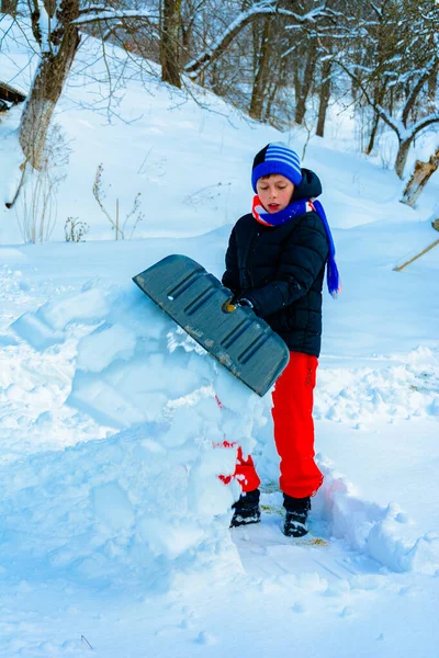 Çocuk kışın evinin yakınındaki karları kürekler.. — Stok fotoğraf