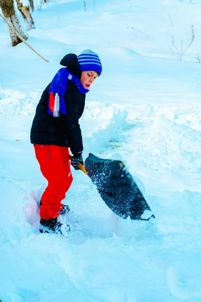 Czyszcząc śnieg w zimie, chłopiec łopaty śniegu. — Zdjęcie stockowe