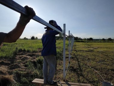 Koruyucu maske işçi kaynak çelik korkuluklar açık havada, kıvılcımlar gökyüzü ve alan arka plan karşı, aşağı sinek.