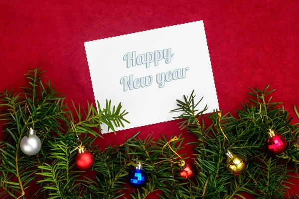 Надпись С Новым годом на красном фоне с елкой и шарами с видом сверху — стоковое фото