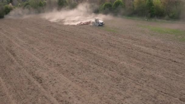 Repülés egy kúszó traktor felett, amely előkészíti a talajt a vetésre azáltal, hogy modern berendezésekkel lazítja el a talajt. — Stock videók