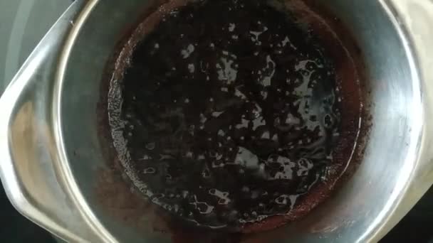 Ev sahibi mutfakta tereyağlı kakao pişirir. Sıcak çikolata kaynatırken kabarcıklı harika bir doku.. — Stok video
