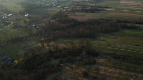 Een klein Europees dorp in Oekraïne vanuit vogelperspectief. Kleine rivieren in de heuvels. Grasverbranding en negatieve gevolgen voor het milieu. — Stockvideo