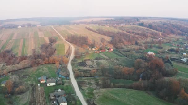 Ein kleines europäisches Dorf in der Ukraine aus der Vogelperspektive. Kleine Flüsse in den Hügeln. Verbrennendes Gras und negative Auswirkungen auf die Umwelt. — Stockvideo