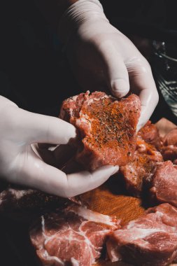 Kebap ve jambon pişirmek için marine edilmiş çiğ domuz eti. Restoranın eldivenli şefi 2021 baharatlı fesleğen ve baharatlı ete iyi davranır..