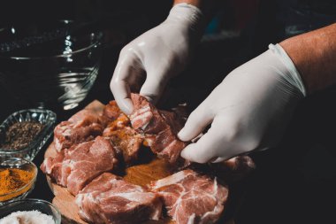 Kebap ve jambon pişirmek için marine edilmiş çiğ domuz eti. Restoranın eldivenli şefi 2021 baharatlı fesleğen ve baharatlı ete iyi davranır..