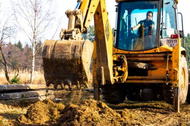Trostyanets, Ukrayna 20 Aralık 2019: Köyde bir kazıcı yolu açıyor, toprak kazıyor ve beton döşemeleri naklediyor. 2020