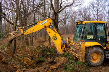 Trostyanets, Ukrayna 20 Aralık 2019: Kazıcı özel bir yarda içinde bir köyde toprak kazıyor. 2020