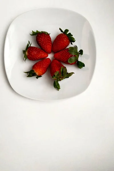 丸みを帯びた白いプレートの上にイチゴ,トップビュー,ジューシーで朝食のための非常に便利な果物. — ストック写真