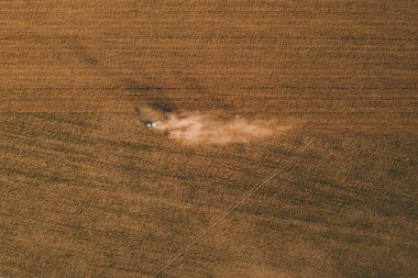 Ukrayna toprakları bir traktör tarafından işleniyor, tarla tahıl ekilmeden önce ekiliyor, üst görünüm, ufukta bir orman görülebiliyor. 2021
