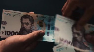 Kadın eli, yeni bir banknot olan Ukrayna Hryvniası 'na 1000 hryvnias' lık bir meblağ olarak geçer..