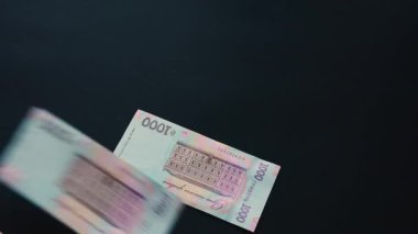 Banknotlar binlerce hryvnianın yüzey değeri, para uçar, siyah bir yüzeye düşer, yeni Hryvnia mezhepleri.