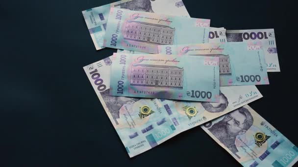 Den ukrainska hryvnia i mängden tusen hryvnias faller, flyger på en svart bakgrund, den ukrainska statens valuta, en hel del räkningar. — Stockvideo