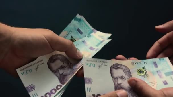 女性の手は、新しい銀行券、千リビアの量で男性の手にウクライナのフリグニアを転送します. — ストック動画