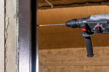 Üstat metal bir kapı çerçevesi takar, kutuya ve duvara monte etmek için delikler açar. 2020