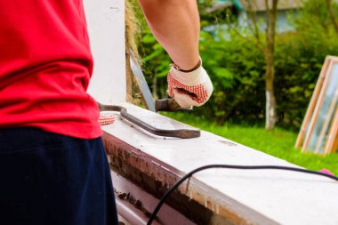 Usta eski pencereyi levyeyle söker, eski pencere çerçevesini levyeyle tartır, sökme işini yapar. 2020