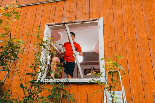 2020 'deki eski pencereyi kaldıran işçiler