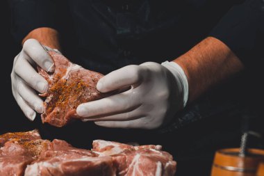 Eldivenli bir adam domuz etini kebap yapmak için baharatla marine eder, tuz, köri ve fesleğen kullanır. 2020