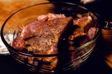 Beyaz eldivenli şef domuz etini baharatlarla ovuyor, köri, fesleğen ve tuz kullanıyor, eti barbeküde marine ediyor. 2020