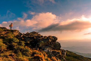 Büyük bir kayanın üzerinde duran küçük bir çocuk Karpatlar 'ın manzarasına hayran, Pip Ivan Chornohirsky Dağı' nın zirvesine. 2020