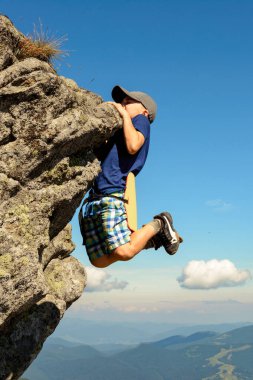 Çocuk dağcılıkla meşgul, bir çocuk kayalık bir dağa tırmanıyor, cesur bir çocuk. 2020