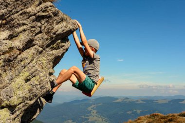 Çocuk dağcılıkla meşgul, bir çocuk kayalık bir dağa tırmanıyor, cesur bir çocuk. 2020