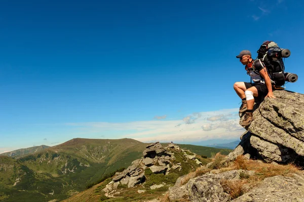 山頂にはリュックを背負った若者が立っており カルパチア山脈の頂上からの景色を楽しむことができます — ストック写真