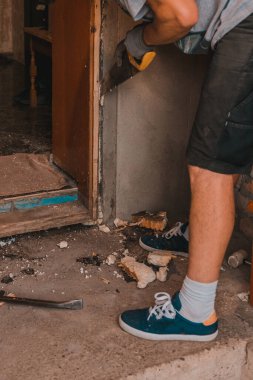 Eski giriş kapılarının sökülmesi, eski ahşap kutu ve kapı, usta kesiyor, duvardan ahşap bir kutuyu kesiyor, bir el testeresiyle. 2020