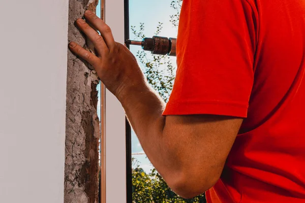 自分の家の男はプラスチック製の窓を設置し 新しい窓を設置し 労働者は電気ドリルを使用します 2020 — ストック写真